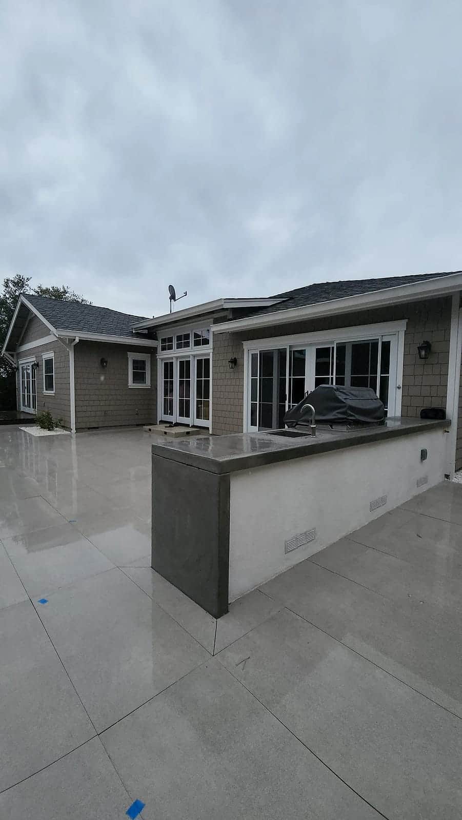 Repainted shingle home over a new backyard patio and outdoor kitchen