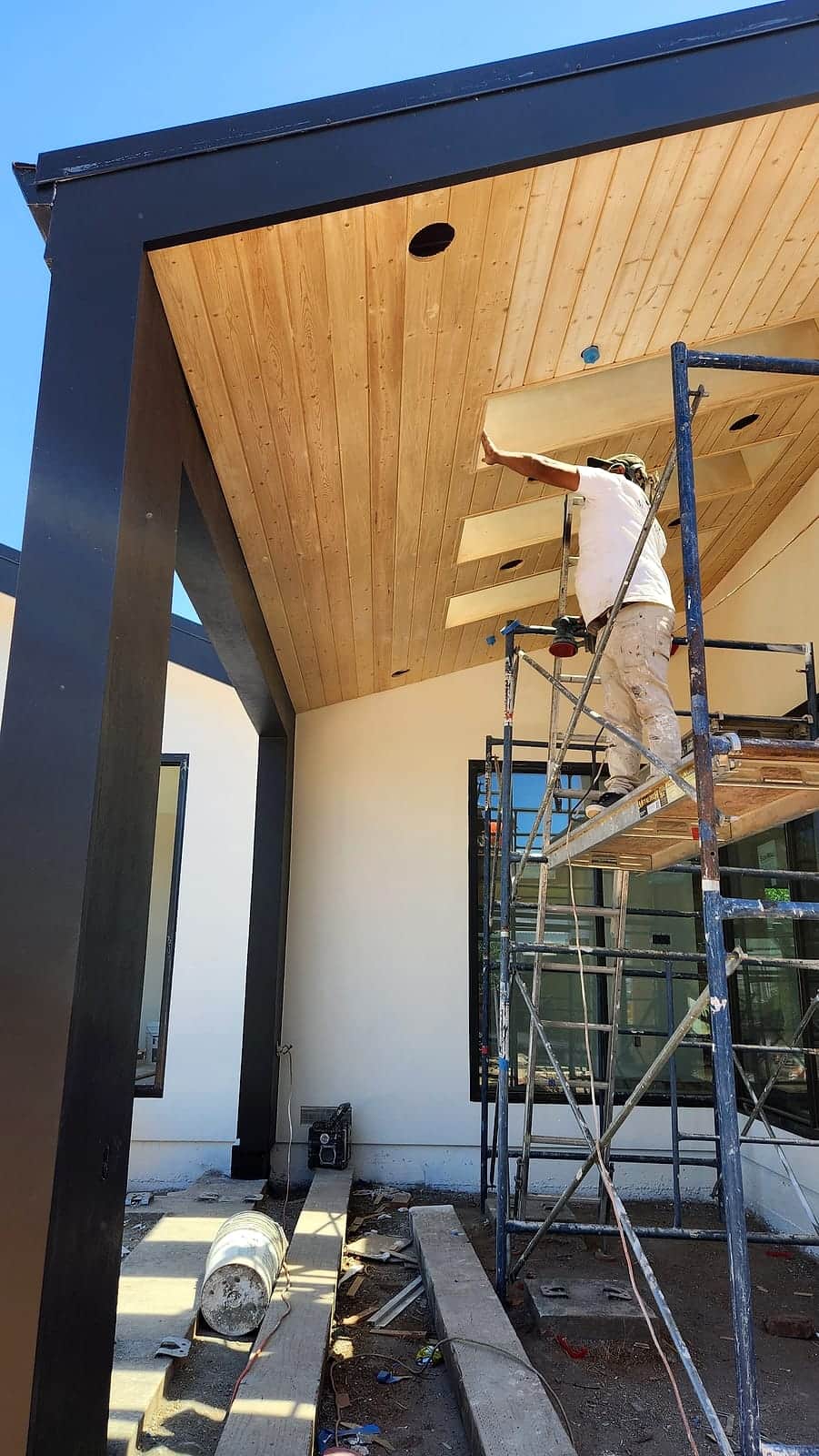 Finishing the wood soffit of a steel pergola from scaffolding