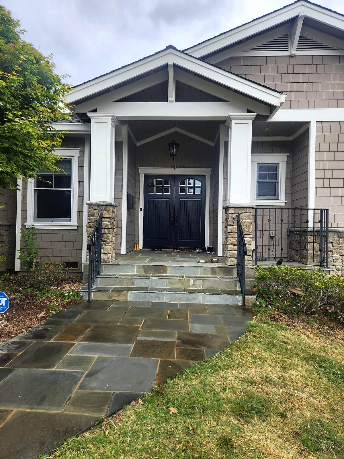 Freshly repainted Craftsman entry with taupe shingle siding, crisp white trim, and a black double front door