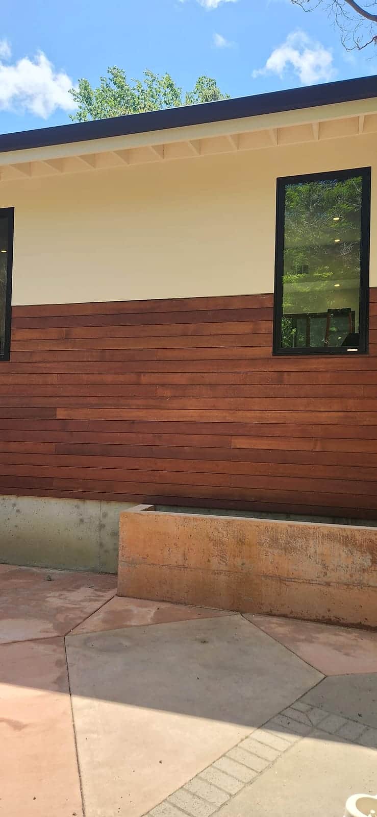 Fresh exterior paint above a rich horizontal wood-slat wainscot