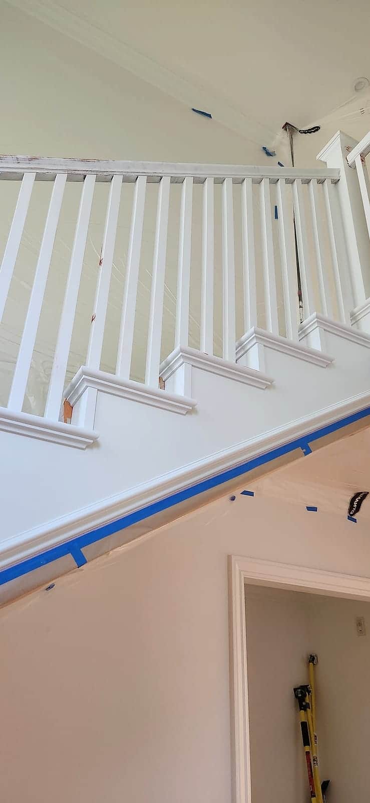 Finished staircase in bright white with clean balusters, handrail, and trim